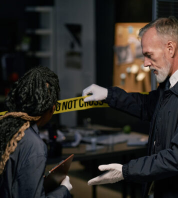 Experienced professionals gathering evidence at crime scene with yellow crime scene tape in background focused on discovering crucial details during investigation process