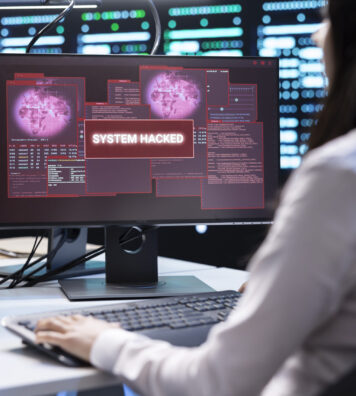 System administrator in server room frightened by sensitive data threatened by hacking attack on computers. Woman afraid of cyberattack, struggling to save data center from unauthorized access